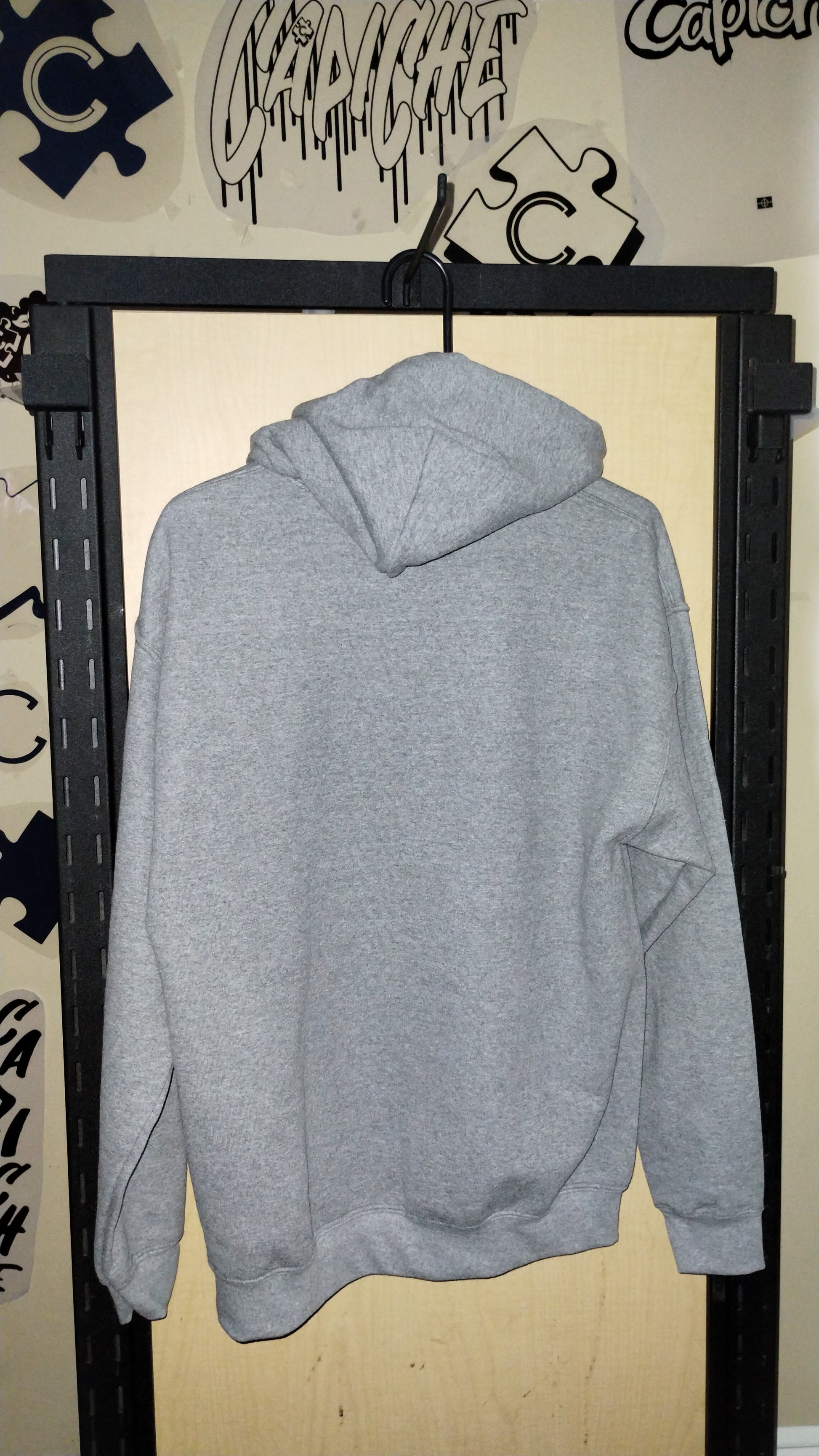 Back of grey hoodie on a hanger