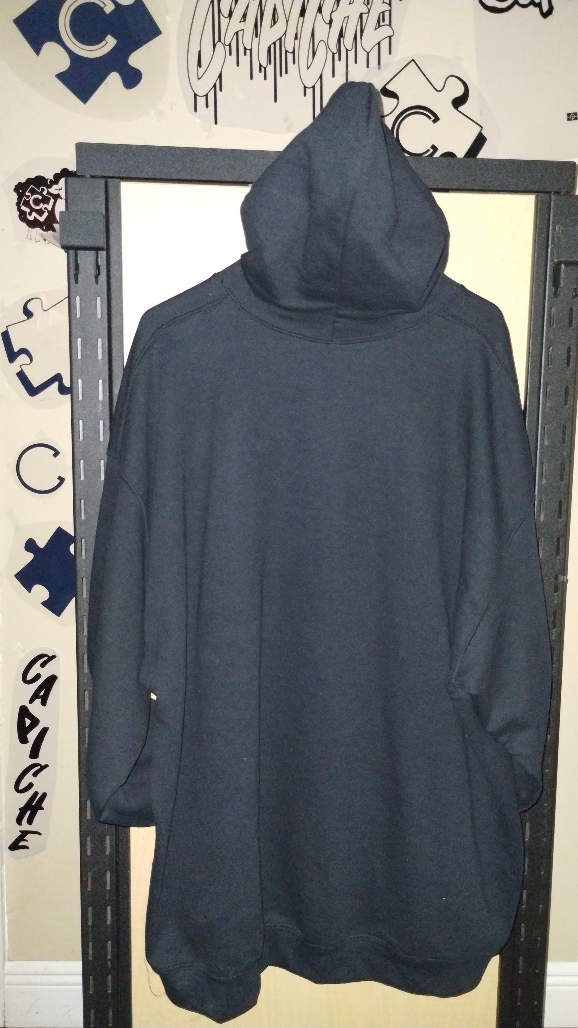 Back view of black hoodie on a hanger