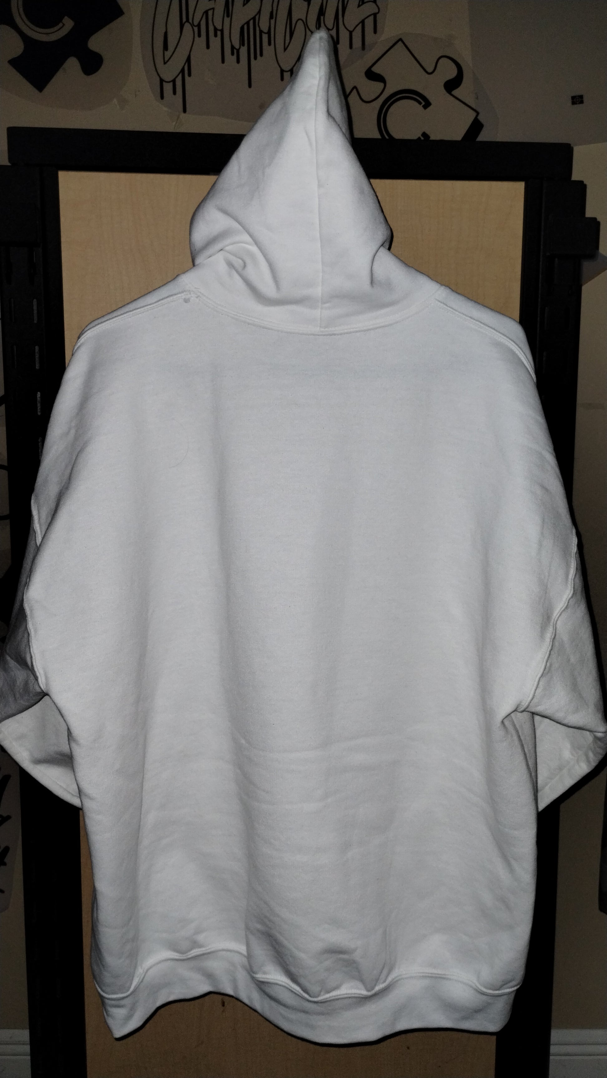 Back of the white hoodie on a hanger