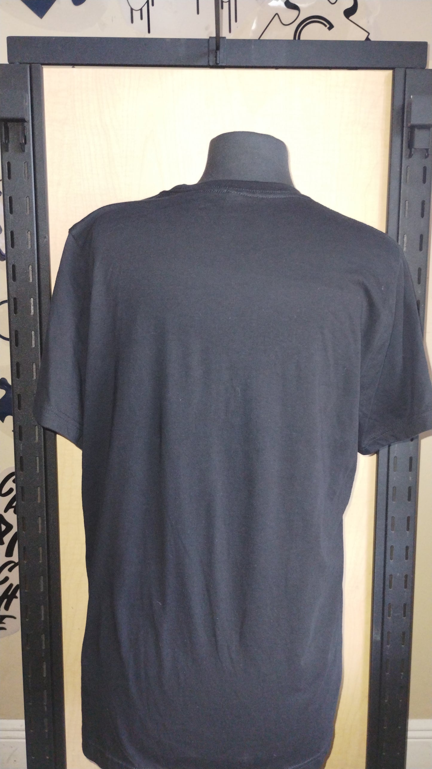 Back view of black shirt on a manikin.